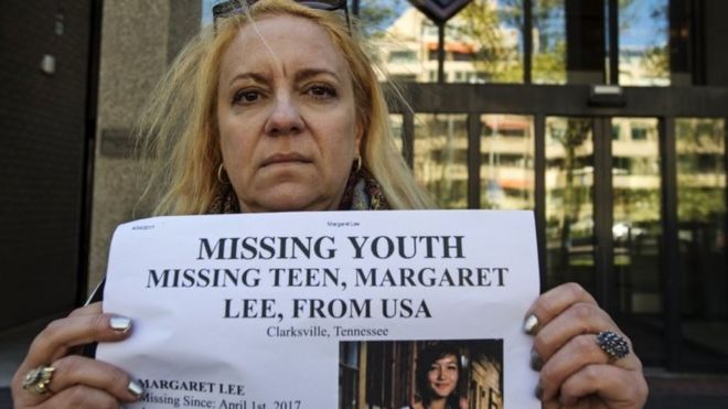 Sabrina Lee, the mother of missing Margaret Lee, poses with a missing poster of her daughter.
