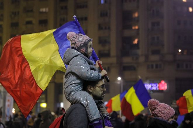 A child carries a Romanian national flag during a demonstration in Bucharest, Romania, 5 February