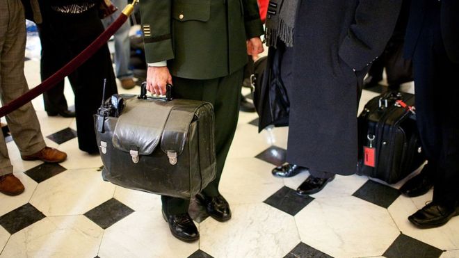 Um assessor militar carrega a "bola nuclear"