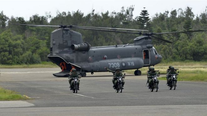 Armed Taiwanese soldiers ride on motorcycles next to a US-made CH-47 helicopter during the 'Han Kuang' (Han Glory) life-fire dril