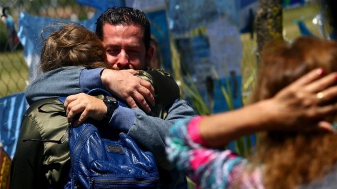 A crying man holds a woman in an embrace outside the Mar del Plata base on 25 November