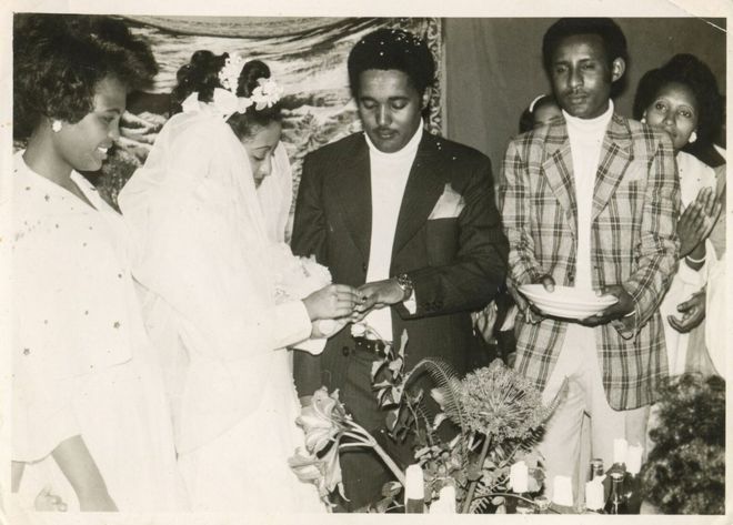 Genet and Aynalem exchanging vows in the presence of a priest and guests at her father’s house.