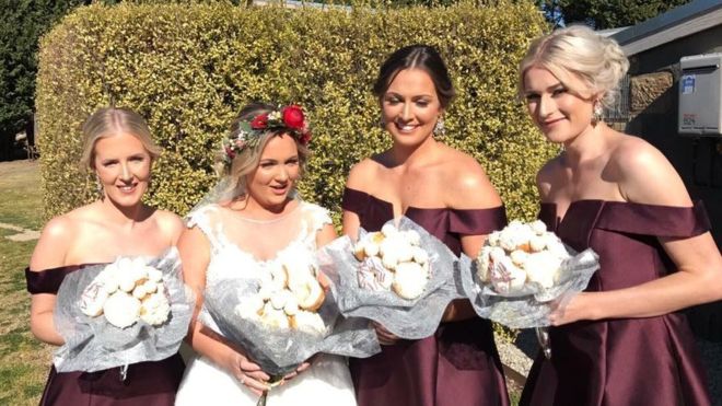 Paige poses with her three bridesmaids with the unusual baked bouquet