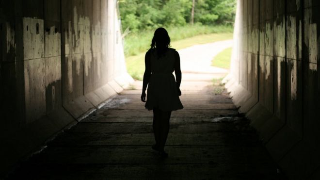 Mulher caminha em túnel