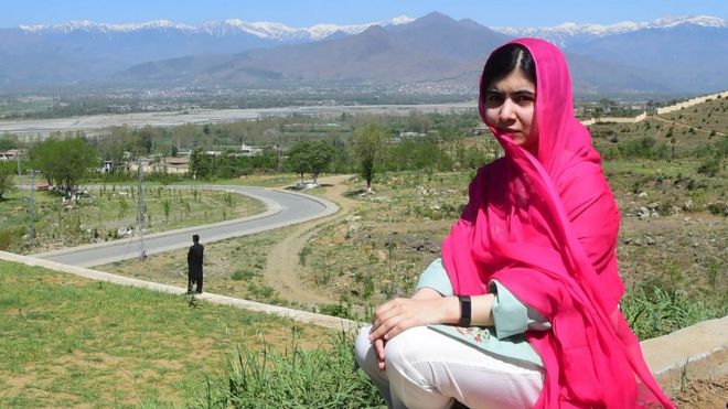 Malala Yousafzai, sat and staring into the camera in Pakistan