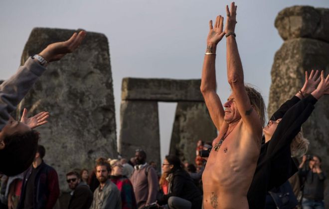 Revellers practice yoga as the sun rises and = they celebrate the pagan festival of Summer Solstice at Stonehenge in Wiltshire, southern England on June 21, 2017.