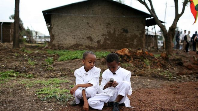 Niños etíopes jugando con un celular
