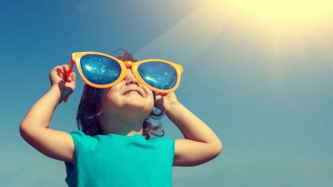 Niña mirando al sol