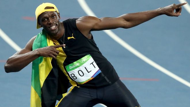 Usain Bolt yarış sonrası başarısını gazetecilere poz vererek kutluyor.