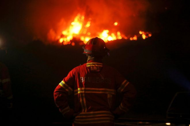 Un bombero observa el fuego devorar el bosque de Carvalho, junto a Gois, en Portugal.