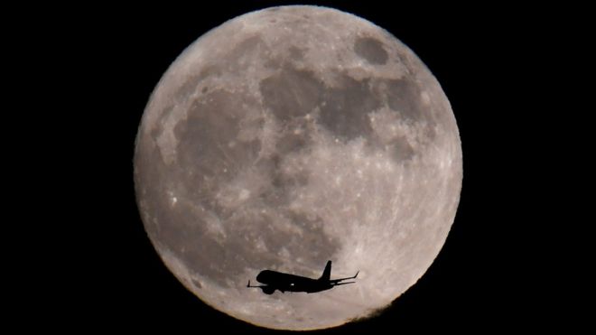 Un avión captado delante de la luna