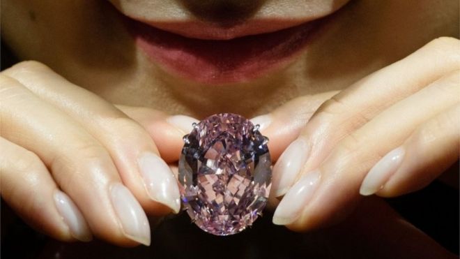 A model poses with a 59.60-carat oval mixed-cut pink diamond, known as "The Pink Star", during a Sotheby"s media preview in Hong Kong on March29, 2017