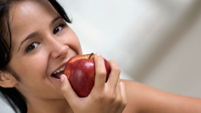 Una mujer comiendo manzana