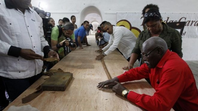 Jose Castelar Cairo, known as "Cueto" (R), presents to the public the world"s longest cigar in Havana, Cuba, 12 August 2016.