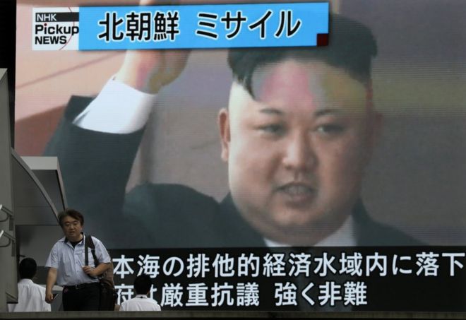 Un hombre camina en Tokio ante una pantalla con la cara del líder norcoreano Kim Jong-un y que reporta el anuncio que hizo Corea del Norte sobre el "exitoso" lanzamiento de un misil balístico "intercontinental" el 4 de julio de 2017.