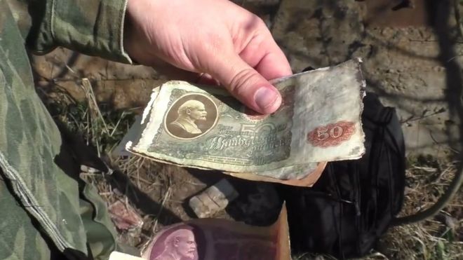 One of the Abandoned Country team holds Soviet-era banknotes