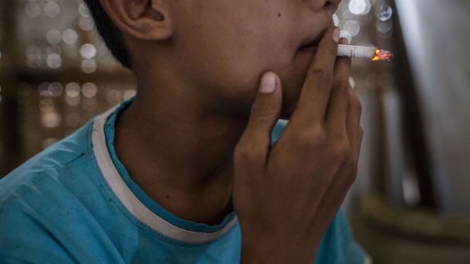 Teenager smokes at a kiosk on March 6, 2017 in Yogyakarta, Indonesia