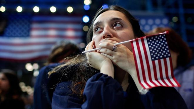 Una seguidora de Hillary Clinton se tapa la boca y mira hacia el horizonte en un evento programado de Hillary Clinton