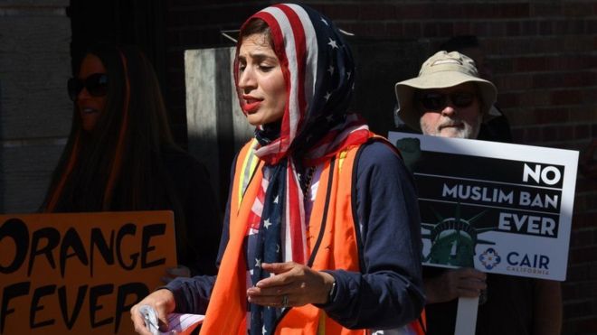 A woman wears a US flag for a headscarf as she participates in the #NoMuslimBanEver rally in Los Angeles in October