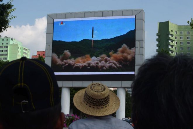 Decenas de ciudadanos ven el lanzamiento de lo que Corea del Norte llamó un misil balístico intercontinental este 4 de julio en una pantalla colocada en la estación central de tren de Pyongyang.