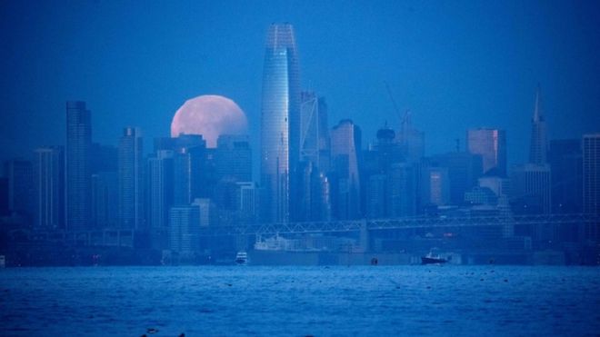 Moon is pictured setting behind San Francisco skyline