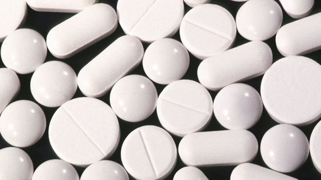 Pílulas e comprimidos brancos sem identificação dispostos em uma bandeja