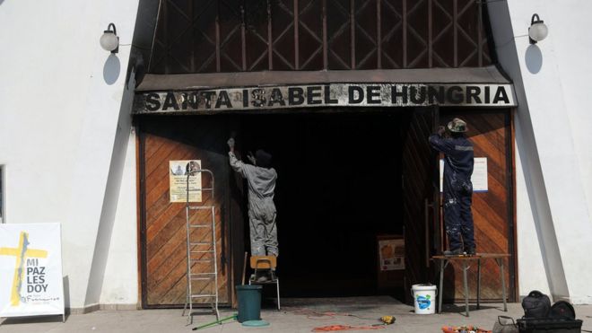 People repair the church of St. Elizabeth of Hungary, where a fire was set on 12 January