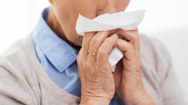 A generic image of a woman blowing into a tissue