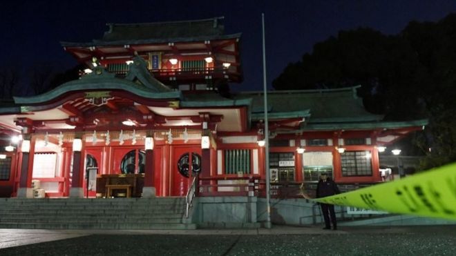 A policeman stands guard in front of the main temple of the Tomioka Hachimangu shrine in Tokyo, Japan in this photo taken by Kyodo on December 8, 2017