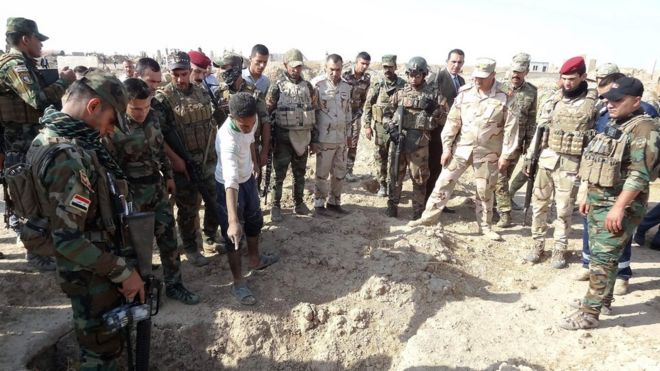 Iraqi forces inspect a mass grave near Hawija, 11 Nov 2017