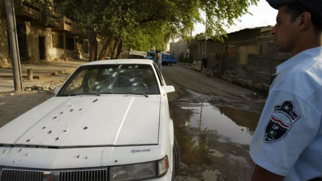 An Iraqi policeman stands by the bullet riddled car of two women shot dead by private security guards in Baghdad, 9 October 2007