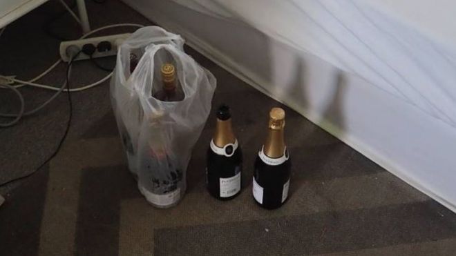 Bottles of champagne sit next to a bed where the intruder was arrested