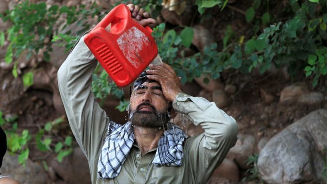 رجل يصب على نفسه مياه مسربة من أنبوب مكسور للتغلب على موجة الحر في إسلام آباد، باكستان