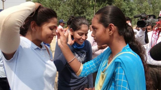 நெற்றியில் பொட்டு வைக்கிறார் ஒரு பெண்.