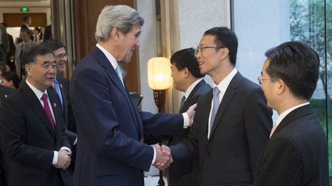 El ex vicepresidente de Estados Unidos John Kerry saluda a unos empresarios chinos.