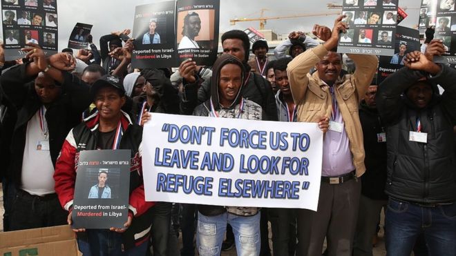 Manifestantes exibem cartazes com fotos de africanos que teriam sido mortos após serem deportados de Israel para seu país de origem durante protesto em janeiro de 2017
