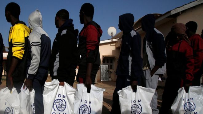 Gambian migrants who returned voluntarily from Libya stand in line with plastic bag from the International Organization for Migration (IOM) as they wait for registration at the airport in Banjul, Gambia April 4, 2017