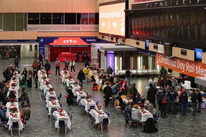 Network Rail volunteers and those from other charities welcome the homeless into the departures and arrivals hall at Euston Station for a Christmas meal