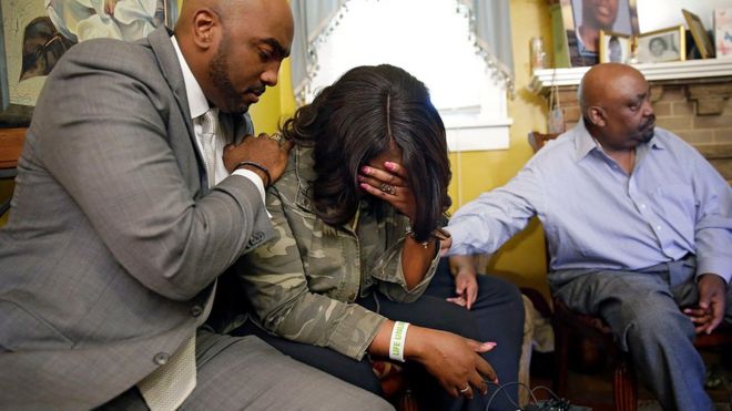 Tiffany (centro), hermana de Terence Crutcher, es consolada por el abogado de la familia, Damario Solomon-Simmons (izquierda), acompañados por el padre de la víctima, Joey (derecha).