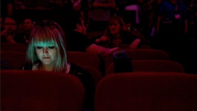 Penonton memakai ponsel di dalam teater bioskop