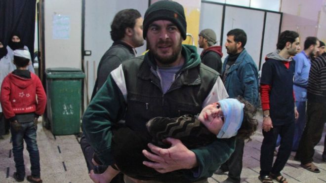 Сириец с ребенком на руках у госпиталя