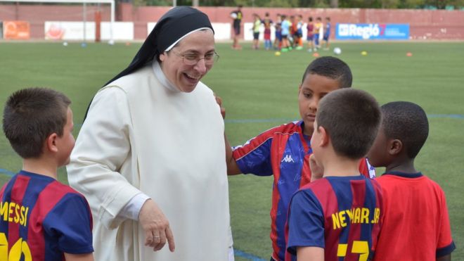 Sor Lucía rodeada de niños en un partido de fútbol.