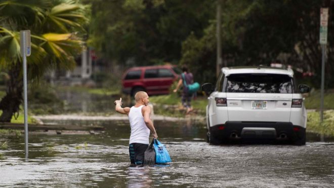 Man wades through flooded street in Florida