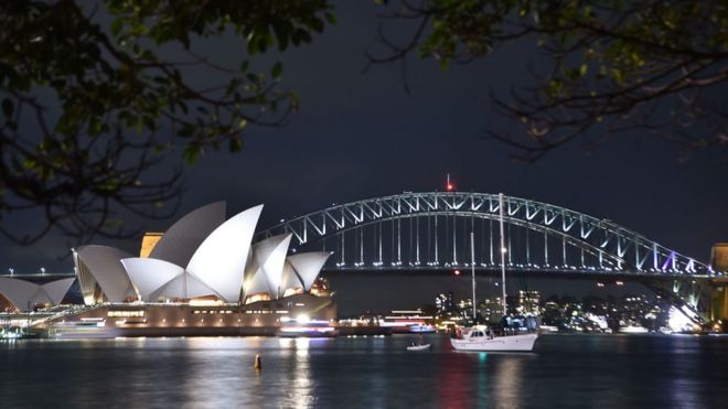 Sydney Harbour Bridge and the Opera House are seen before being plunged into darkness for the Earth Hour environmental campaign on 24 March 2018.