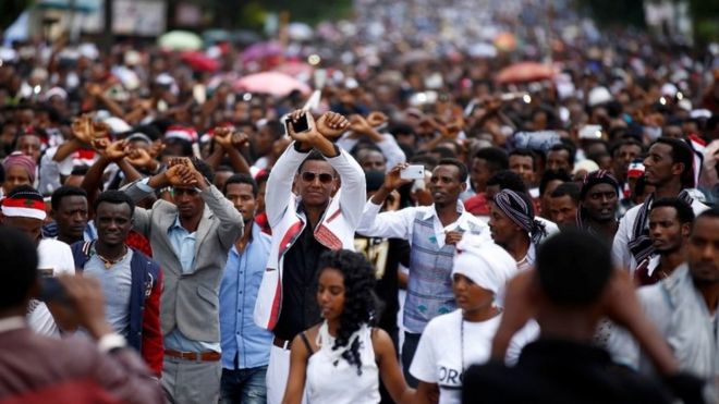 Demonstrators show the Oromo protest gesture sign during Irreecha, the thanks giving festival of the Oromo people in Bishoftu town of Oromia region, Ethiopia, October 2