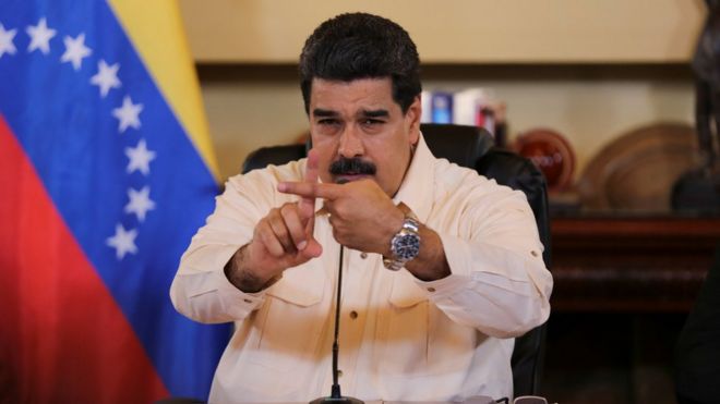 Venezuela's President Nicolas Maduro gestures toward the camera with crossed index fingers, during a meeting with ministers in Caracas