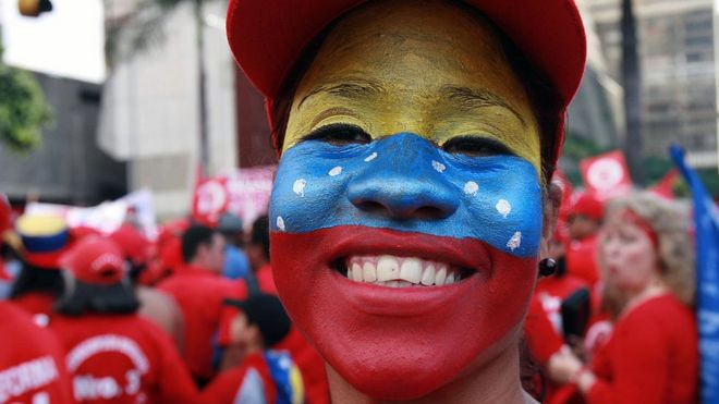 Mujer con la bandera de Venezuela pintada en su rostro.