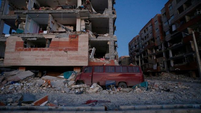 A damaged van and buildings are seen following a 7.3-magnitude earthquake at Sarpol-e Zahab in Iran