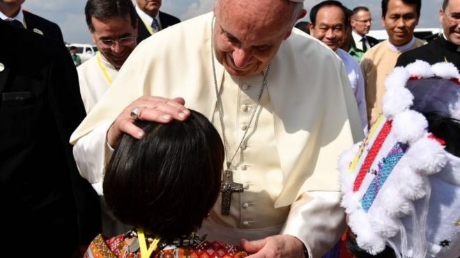 Pope Francis is greeted by a child upon his arrival at Yangon International Airport on 27 November 2017.