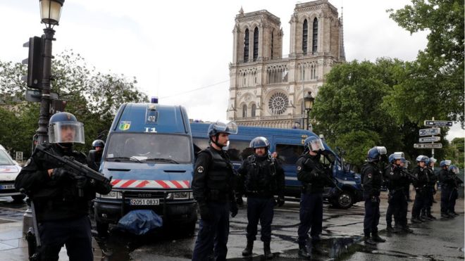 French police stand at the scene of a shooting incident near the Notre Dame Cathedral in Paris